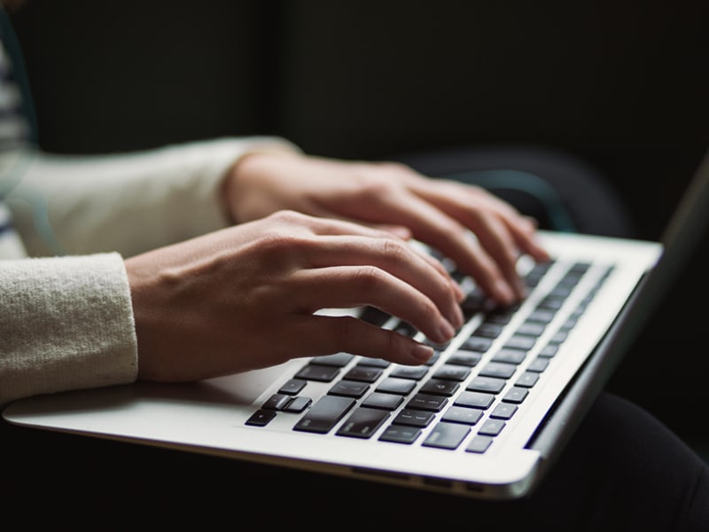 Writing a counselling case study - hands over a laptop keyboard